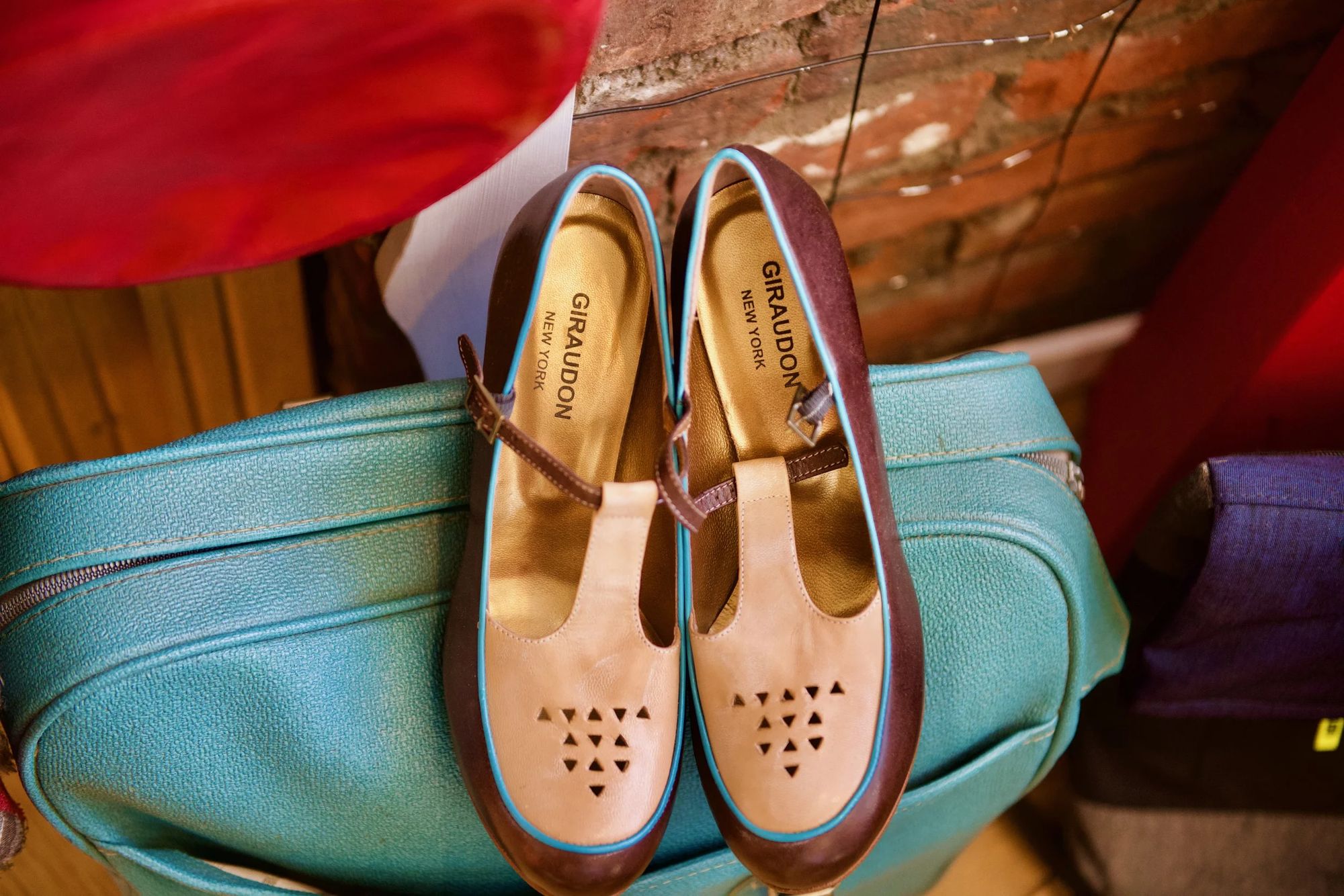 Giraudon T-strap shoes resting on a turquoise vintage bag