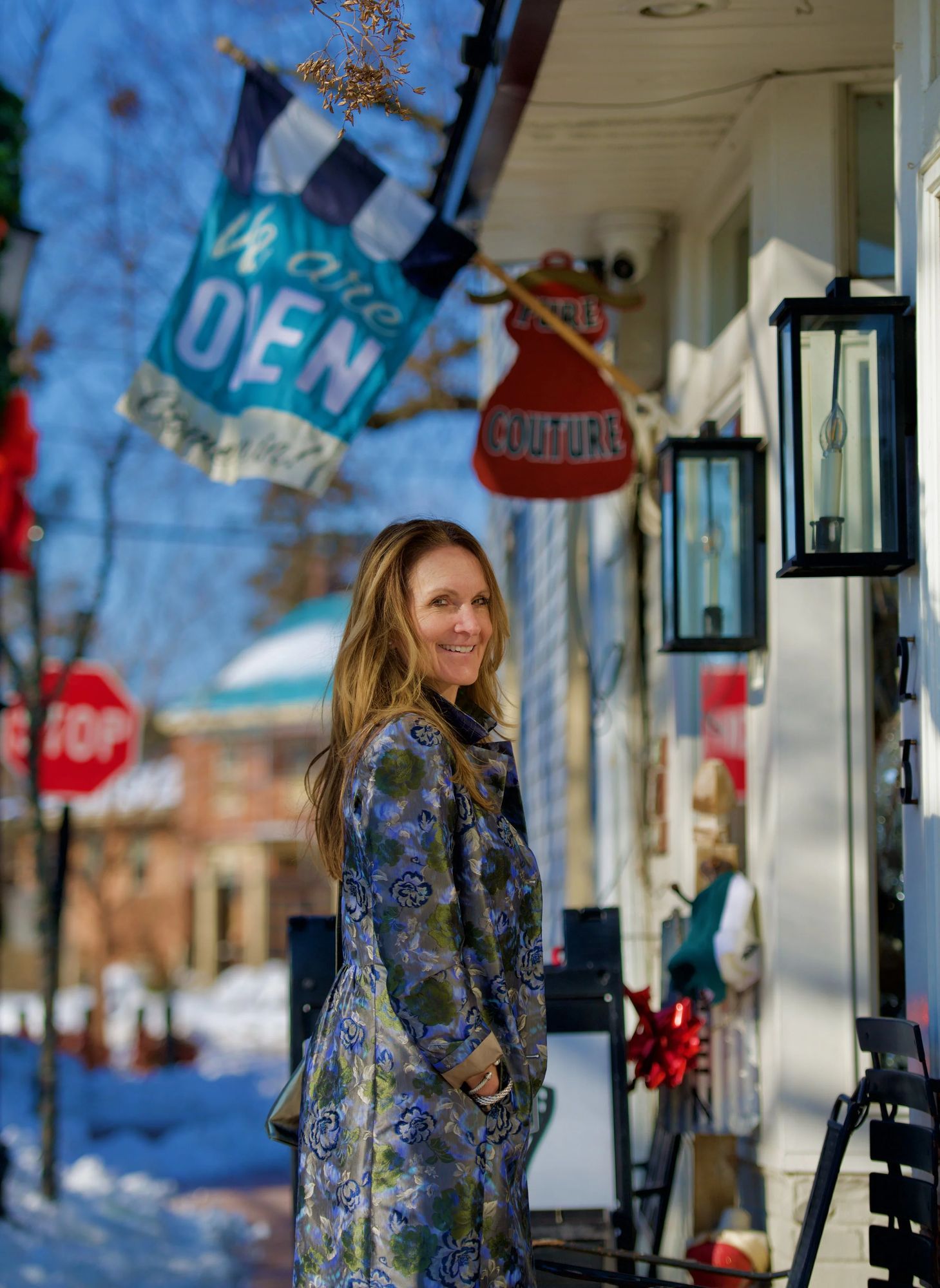 Denise outside the Pure Couture storefront on Mechanic Street, under the Open flag